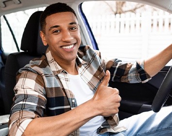 Man smiles in car