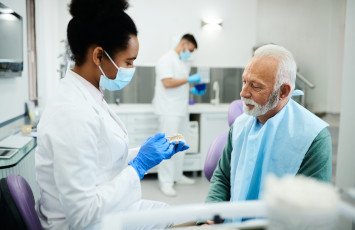 A dentist talking to an older man bout dentures