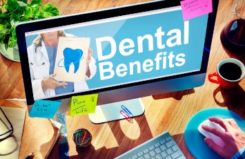 A dental patient looking at a computer screen that’s labelled ‘dental benefits.’