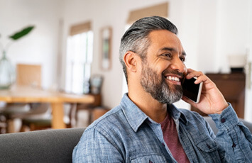 man smiling while talking on cellphone