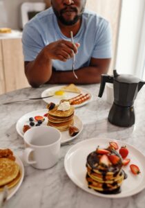 Man eating breakfast foods at a table