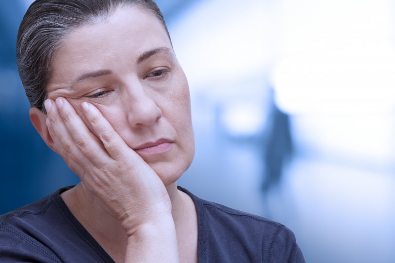 Patient rubbing their cheek due to dental emergencies